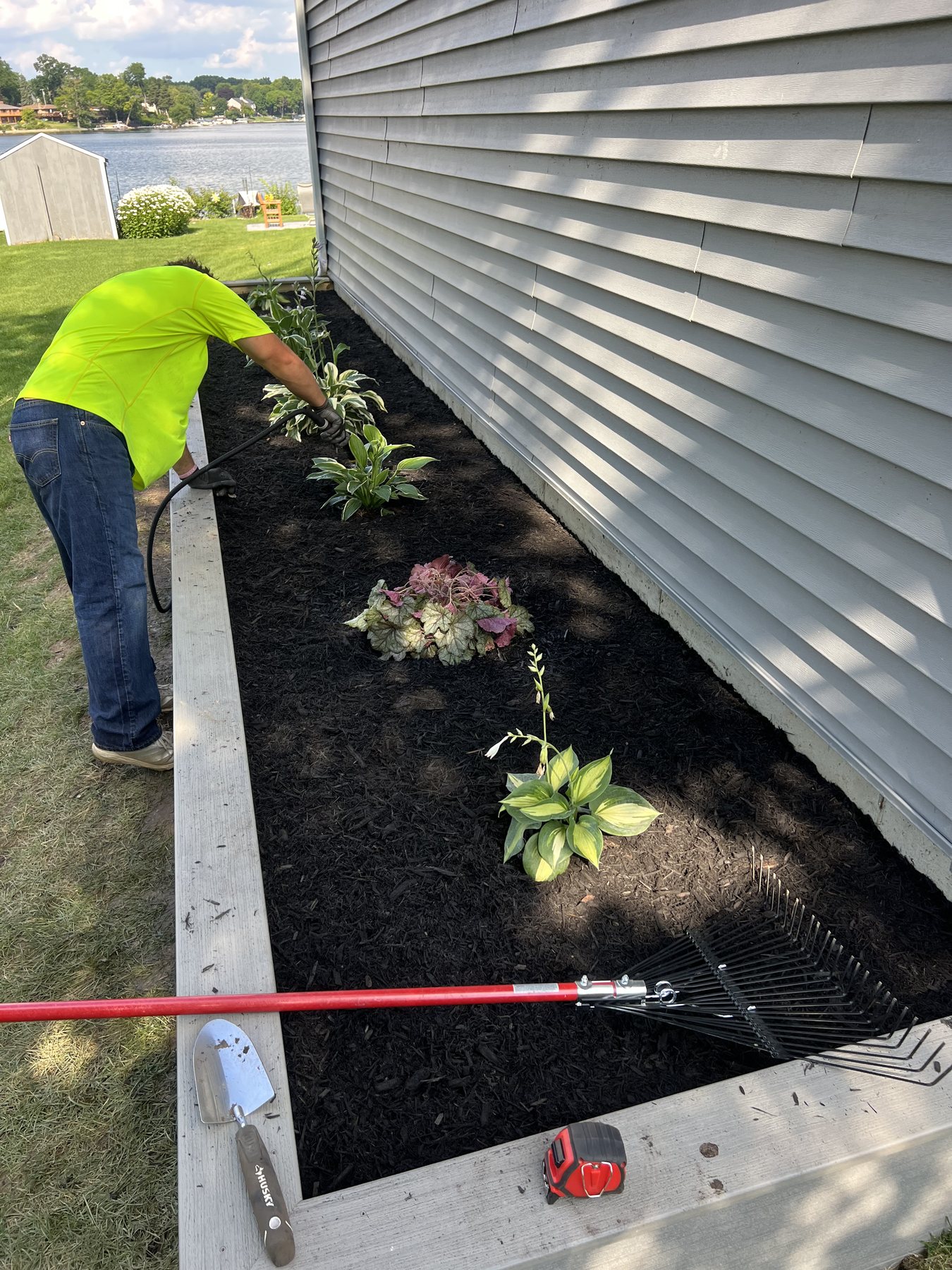Watering new plantings in a raised bed on a lake lot