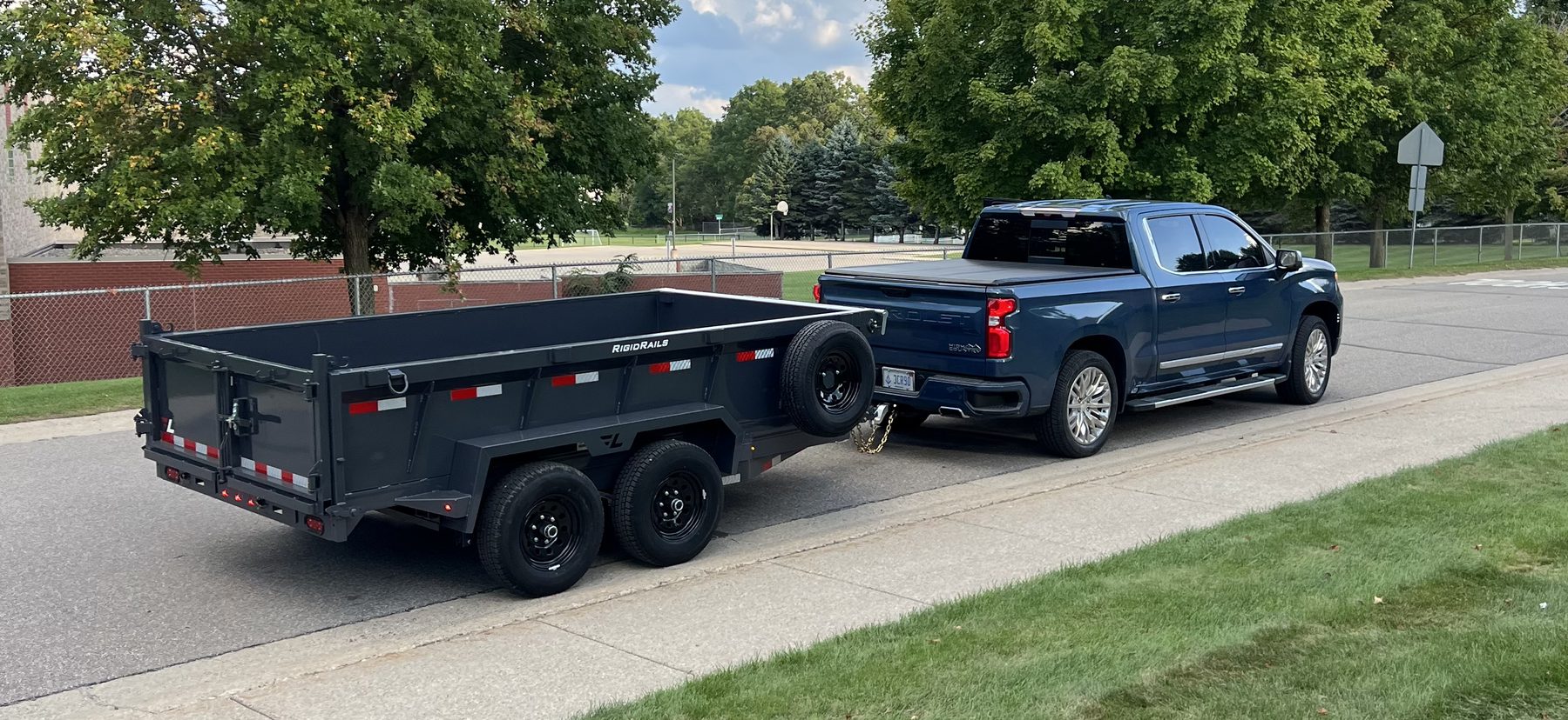 Blue pickup and dump trailer, truck and trailer both in frame