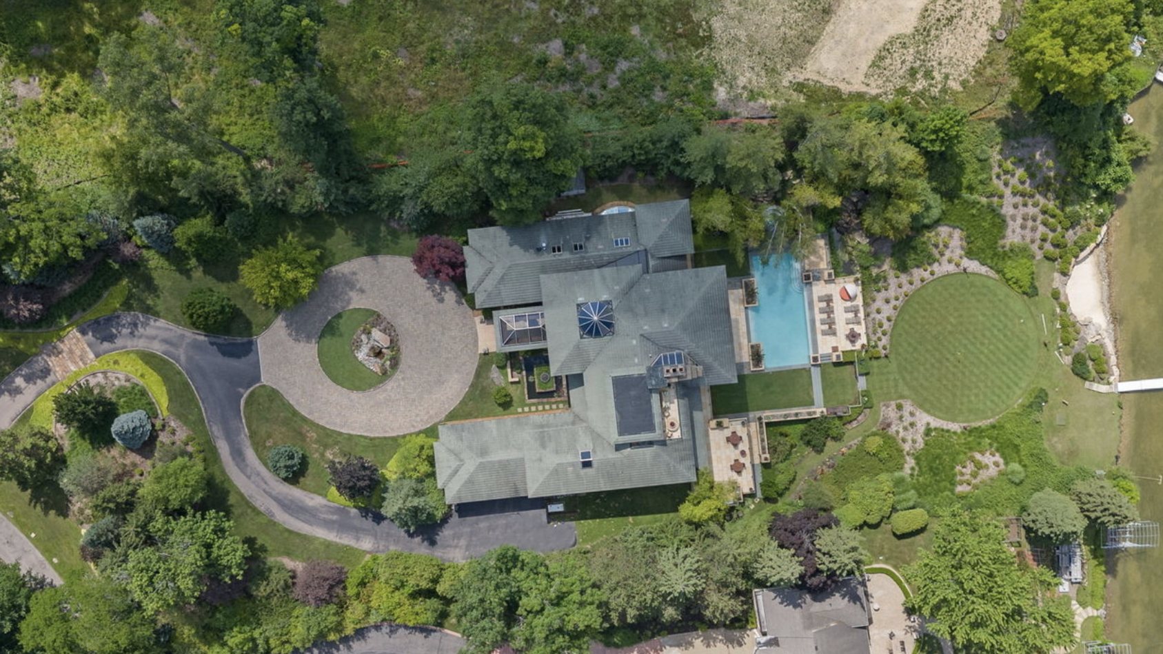 Aerial of a waterfront estate lawn and putting green — Oakland County